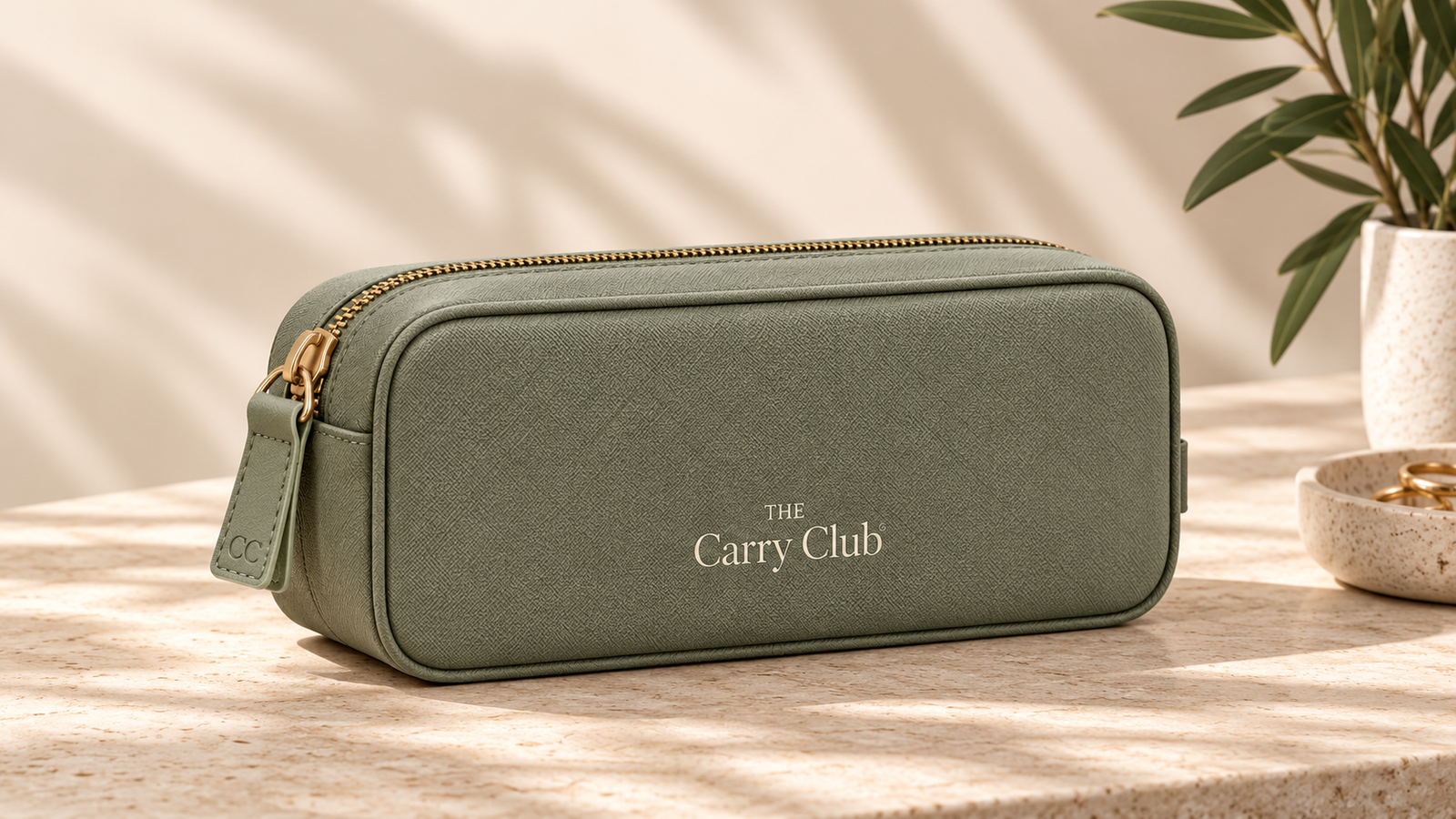 The Carry Club Everyday Organiser in Sage on a sunlit travertine surface
